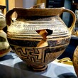 © fab4adobestock - Ancient pottery jar with a prominent solar symbol, intricate black geometric patterns, and a crack, displayed at Palazzo Altemps in Rome. Rome, Italy – December 2, 2024