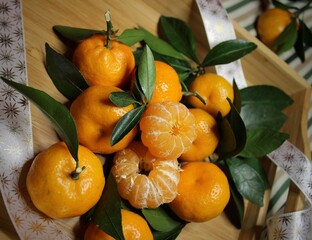 Juicy tangerines with green foliage on a wooden table. Citrus fruits. Ripe fruits. Vitamins. A fresh crop of tangerines. Christmas. Amazing natural background. Juicy texture. Winter 