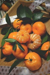 Juicy tangerines with green foliage on a wooden table. Citrus fruits. Ripe fruits. Vitamins. A fresh crop of tangerines. Christmas. Amazing natural background. Juicy texture. Winter 