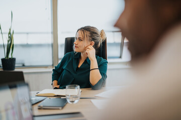 Wall Mural - A focused businesswoman sits attentively in a modern office meeting room. She is surrounded by technology, indicating a professional business environment with a multicultural team.