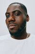 © SHOTPRIME STUDIO - Portrait of a confident male model with a focused expression, wearing a simple white shirt, showcasing his sharp features against a neutral light gray background, emphasizing masculinity and self ass