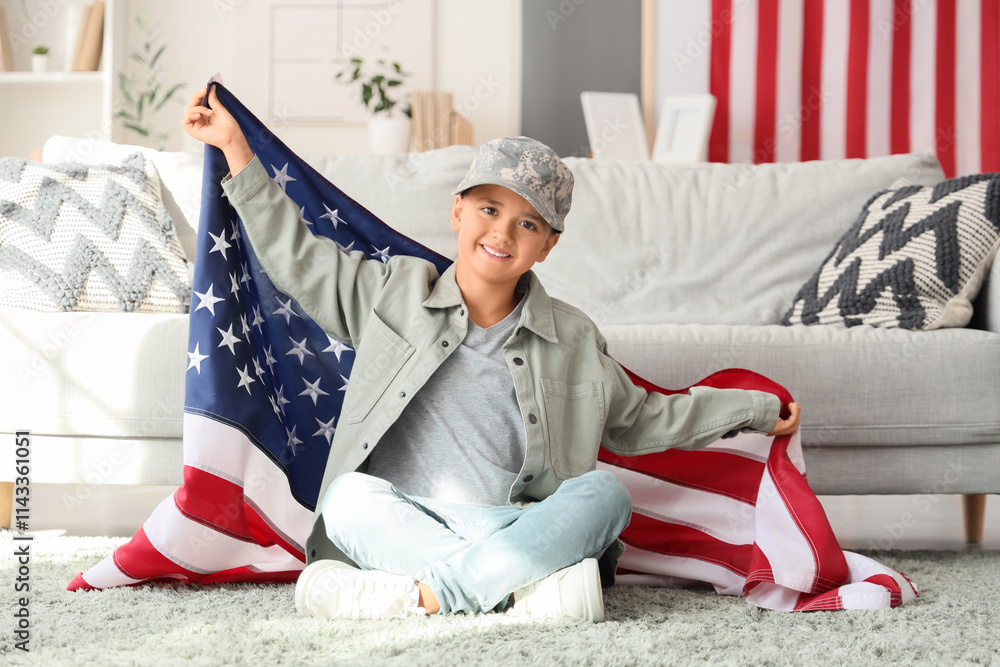 Cute little boy with USA flag sitting at home. Veterans Day celebration