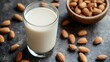© Ben Kuang - A glass of creamy almond milk surrounded by whole almonds.