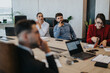 © qunica.com - A group of multicultural business people intensely engaged in a meeting around a conference table. The atmosphere is professional and collaborative, fostering creativity and teamwork.