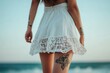 © Space Priest - A woman with tattoos on her arm and leg is wearing a white skirt