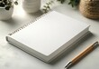 © ANUAR - Blank Spiral Notebook and Wooden Pencil on Minimalist Desk Surrounded by Plants, Perfect for Creative Ideas and Note-Taking in an Inspiring Environment