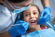 © StreamPixel - dentist examining a young girl's teeth. The dentist is wearing protective gloves and a mask