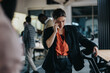 © qunica.com - Confident businesswoman speaking on her mobile phone in a lively office setting, surrounded by colleagues. Image portrays a dynamic workplace atmosphere highlighting communication and collaboration.