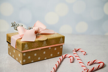 Festive gold gift with pink ribbon, glitter decor, and candy can