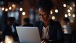 © fotofabrika - Young woman working on laptop in a busy cafe during an evening