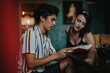 © qunica.com - A young couple engaged in reading and discussing a book inside a cozy cafe setting, showcasing connection, learning, and leisure.