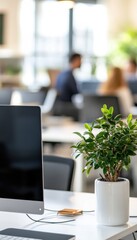 Aufkleber - Close-up of an iMac and a small plant on a desk in a modern office environment with colleagues in the background