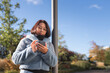 © Johnér - Low angle view of mid adult woman standing by pole on sunny day