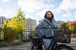 © Johnér - Thoughtful young woman standing by bicycle on road against sky
