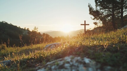 Wall Mural - serene sunset over mountain landscape featuring cross on grassy hill foreshadowing peace and reflect