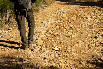 Man hiking on a rocky path in nature on a sunny day with copy space