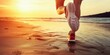 © Iryna - A person is running on the beach at sunset. The sky is orange and the water is calm