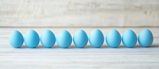 Poster - Blue Easter eggs lined up on a light gray wooden background with space for text and decoration for spring traditions and celebrations