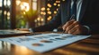 © anantachat - Wealth manager giving a presentation with graphs to a client in a modern office representing efficiency in wealth management Stock Photo with side copy space