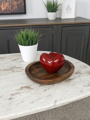 Wall Mural - Red heart sculpture in wooden bowl on marble table.