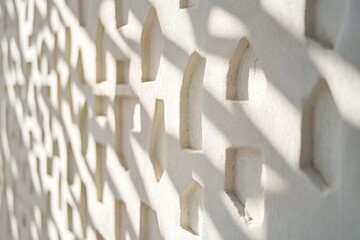 Poster - Light casts shadows on textured white wall with geometric cutouts.