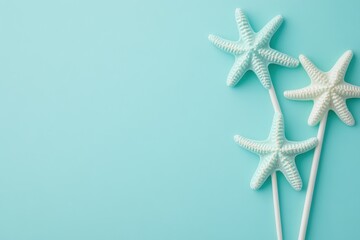 Fototapete - Three starfish on sticks, light blue background.