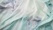 © Mykhailo - Flowing silk fabric in soft mint green and lavender hues with subtle watercolor-like stains, creating a tranquil and artistic texture reminiscent of gentle abstract patterns