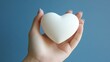© tono boys - Woman's hand holding a white heart.