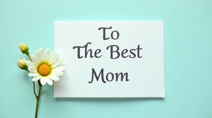 Wall Mural - A card for Mother's Day with text To the Best Mom and a small flower beside it on a pastel teal background