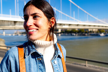 Wall Mural - A happy woman enjoying the moment, smiling and looking out at the view on a beautiful, sunny day