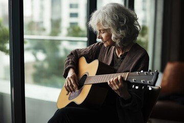 Old white woman playing acoustic guitar indoors