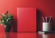 © ANUAR - Aesthetic Red Workspace with Minimalist Notebook, Potted Plant, and Colorful Pens on a Vibrant Red Table for Creative Inspiration and Productivity