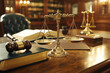 © Vasili - A legal desk setup with scales of justice, gavel, and law books in a warm-lit traditional office. Represents law, justice, and legal authority.