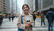 © Flash - A smiling Asian woman in a beige coat, gray scarf, and holding a coffee cup, on a city street.