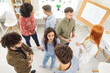 © Studio Romantic - Group of company employees standing in office during business meeting, discussing company strategy. Team of colleagues enjoying casual conversation, exchanging ideas and opinions together. Top view.