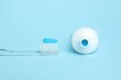 © New Africa - Toothbrush with toothpaste and tube on light blue background