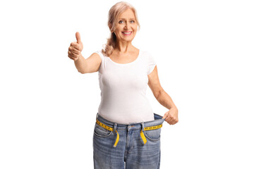 Wall Mural - Middle aged woman gesturing thumbs up and trying on jeans