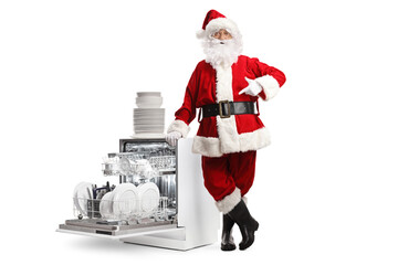 Poster - Full length portrait of Santa Claus leaning on a dishwasher with a pile of clean dishes