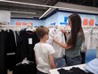 © Anastasiya - A boy and his mother choose a school uniform in a store. Mom and son choose clothes in the store