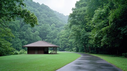 Canvas Print - Rain-soaked pavilion in lush green valley.