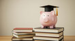 © Anomal - A pink piggy bank wearing a graduation cap sits atop stacked books, symbolizing education savings and financial planning for students.