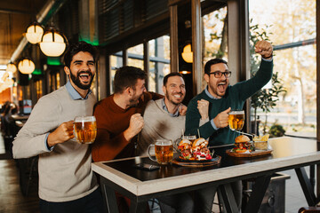 Wall Mural - Group of friends drinking beer and have fun in beer bar