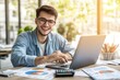 © Maxim Borbut - Using his laptop, smiling businessman in glasses calculates bills, manages finances, young man plans budget at home at desk, browses online banking, satisfied with money refund