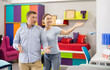© JackF - Smiling couple choose and consider furniture in furniture store
