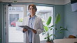 © stockbusters - Healthcare professional standing clipboard in hospital closeup. Serious woman