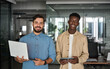 © insta_photos - Two confident diverse business men professional people partners work team, male company employees workers looking at camera standing together in corporate office. Portrait.