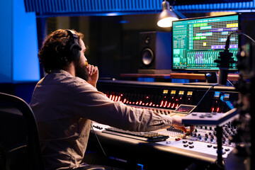 Aufkleber - Audio expert operating on control desk with motorized faders and mixing console in professional studio, using sliders and knobs to process sounds. Music engineer producer recording tracks.