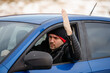 © Dinno - An irritated young man driving a vehicle is expressing his road rage.