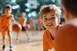 © LifeMedia - A smiling young boy in an orange jersey plays energetically with peers in a lively basketball practice session, depicting youthful joy and teamwork amid sunny outdoors.