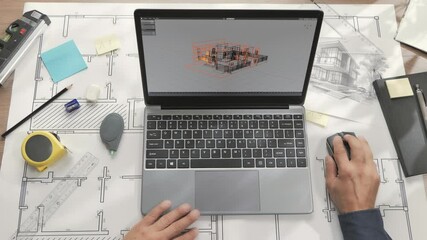 Top down view of architect at the desk designing modern house using laptop,projecting residential building at the computer,3d graphic application mockup